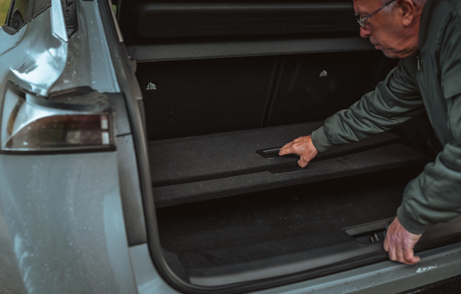 Hans Gustav viser frem ulike inndelingsmetoder i bagasjerommet til Nissan Ariya.